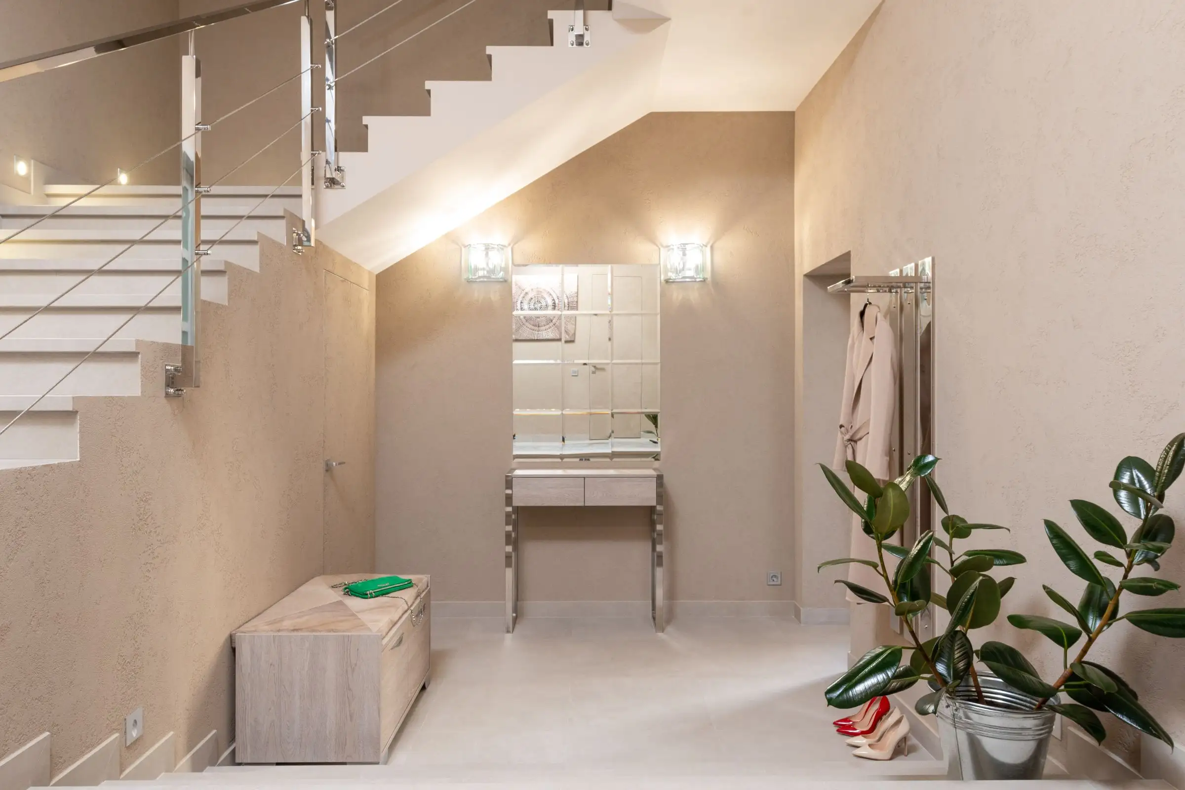 Départ d’escalier clair avec plantes dans le hall