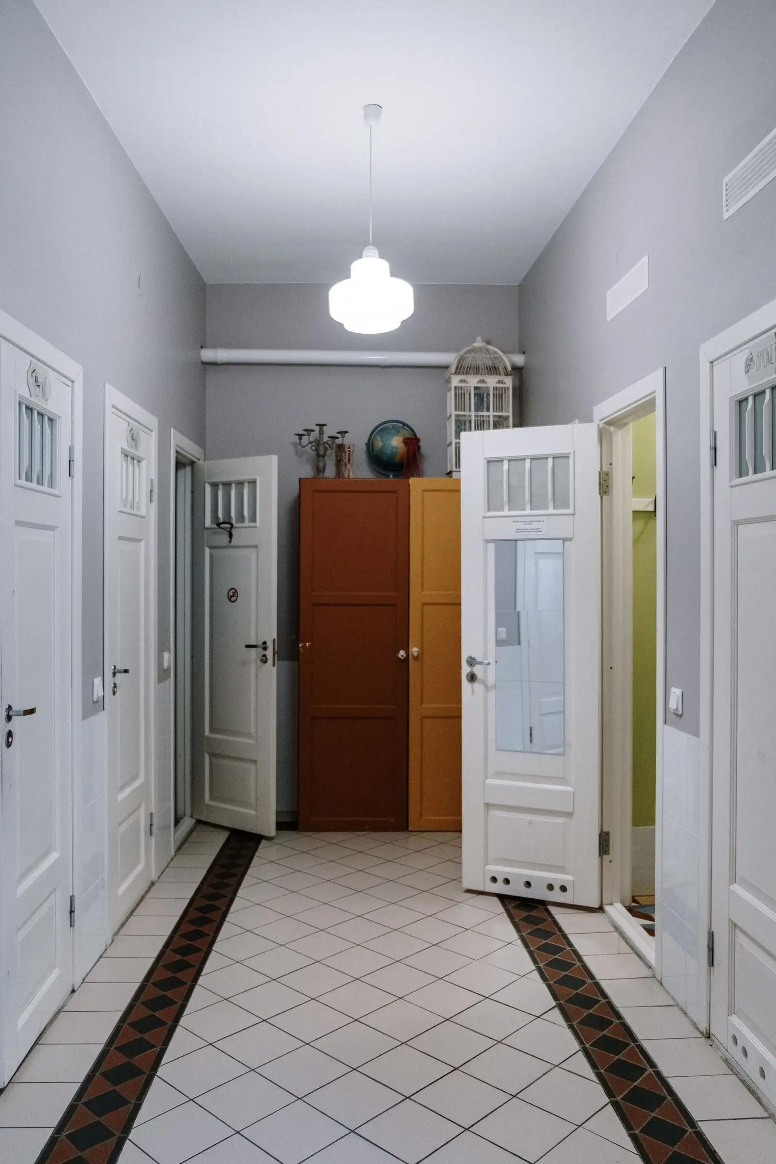 Hall d’entrée d’immeuble avec carrelage à motifs et portes vitrées