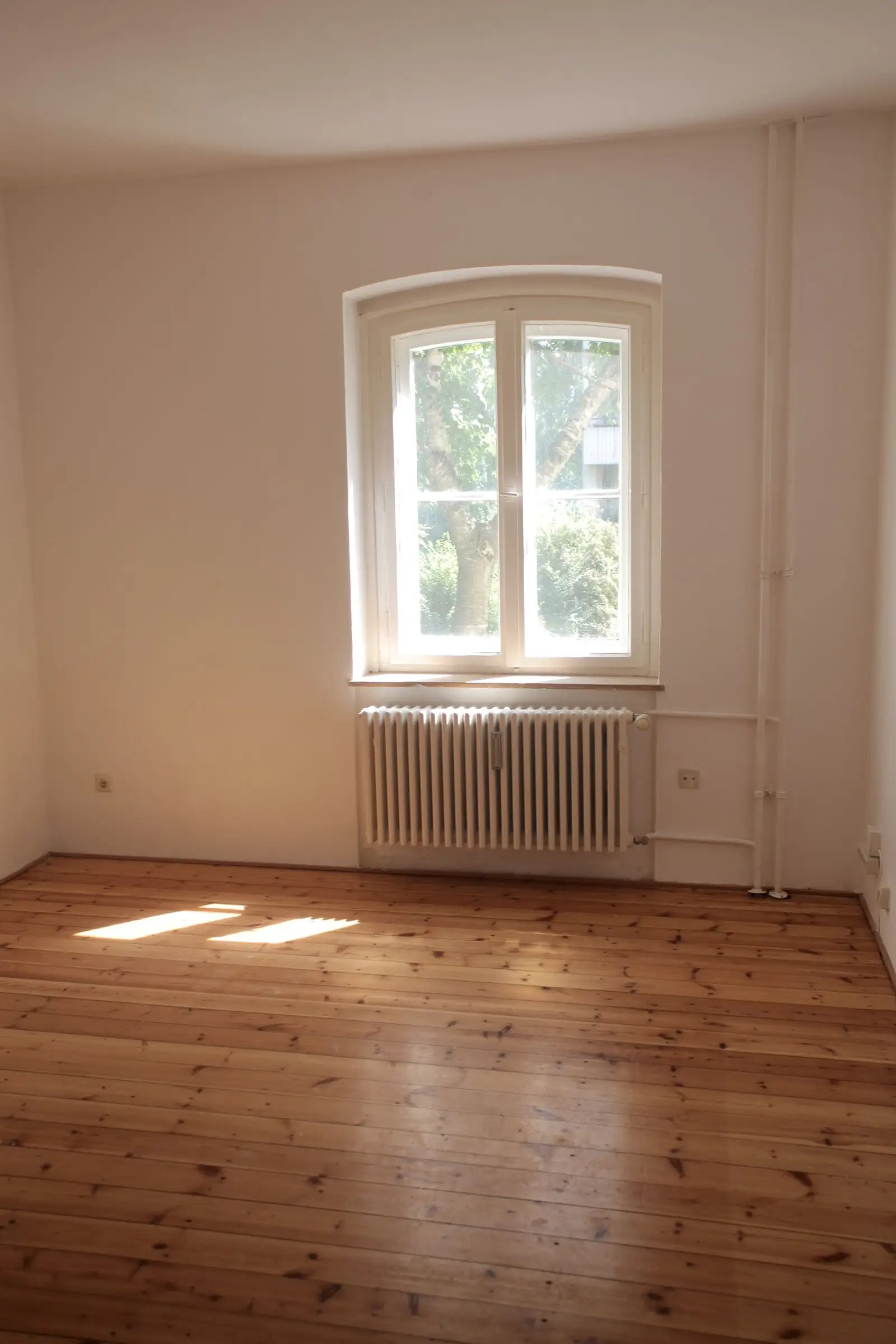 Chambre avec parquet poncé et huilé devant une fenêtre ancienne