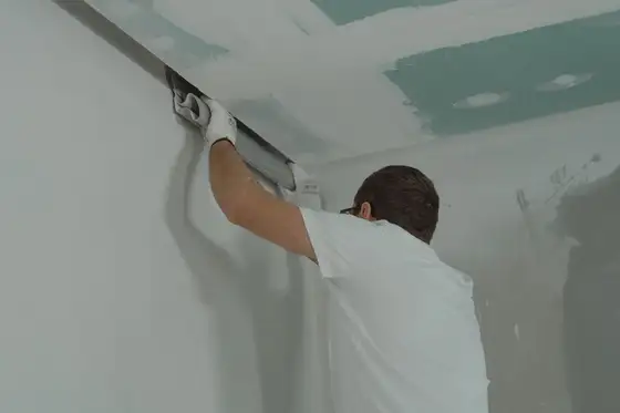 Plâtrier de dos travaillant au plafond