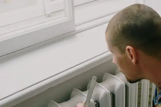 Installateur près d’un radiateur avant raccordement