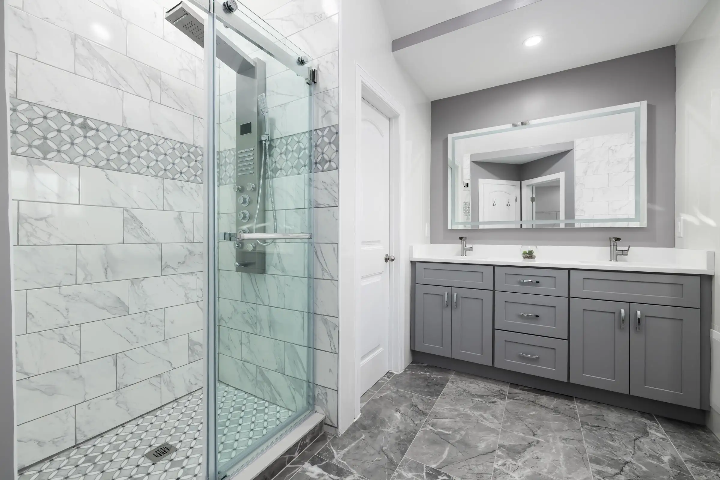 Bathroom with a grey vanity unit and a glazed shower